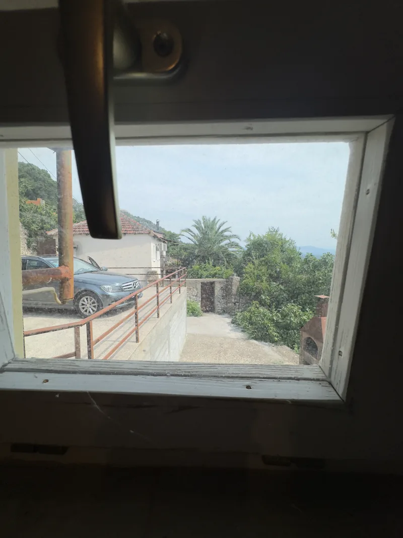 Pogled iz prozora prema terasi, palmi i dolini Ljubuškog